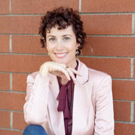 A smiling woman A smiling, well-dressed woman with dark curly hair